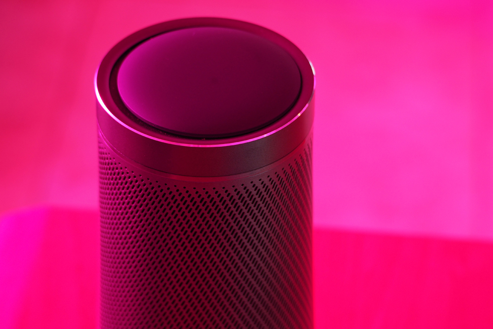 Modern audio speaker with voice assistant. Pink LED technology light